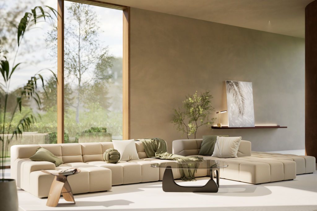 Modern living room with a neutral sectional sofa, green throw pillows, glass coffee table, and large windows with natural light.