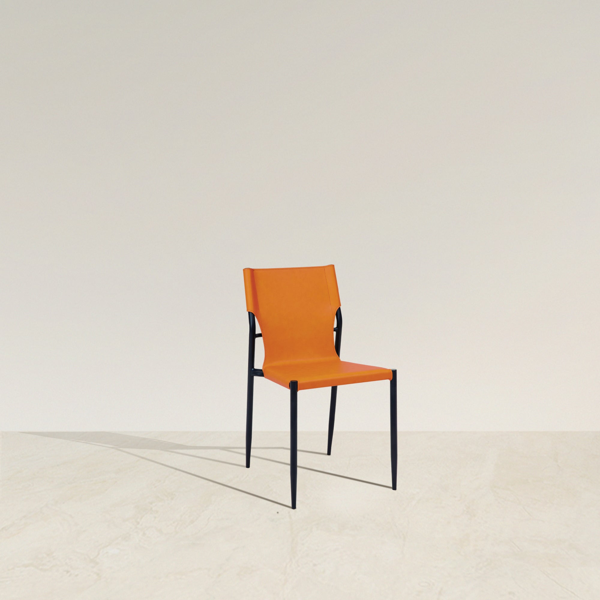 Amir Saddle Leather Chair - Saddle Dining Chair — Its bold sunset orange tone adds a vibrant pop of color, instantly liven...